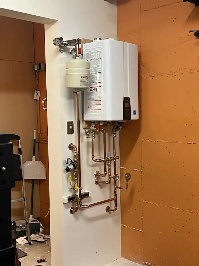 Plumbing technician inspecting water heater connections in Penitas